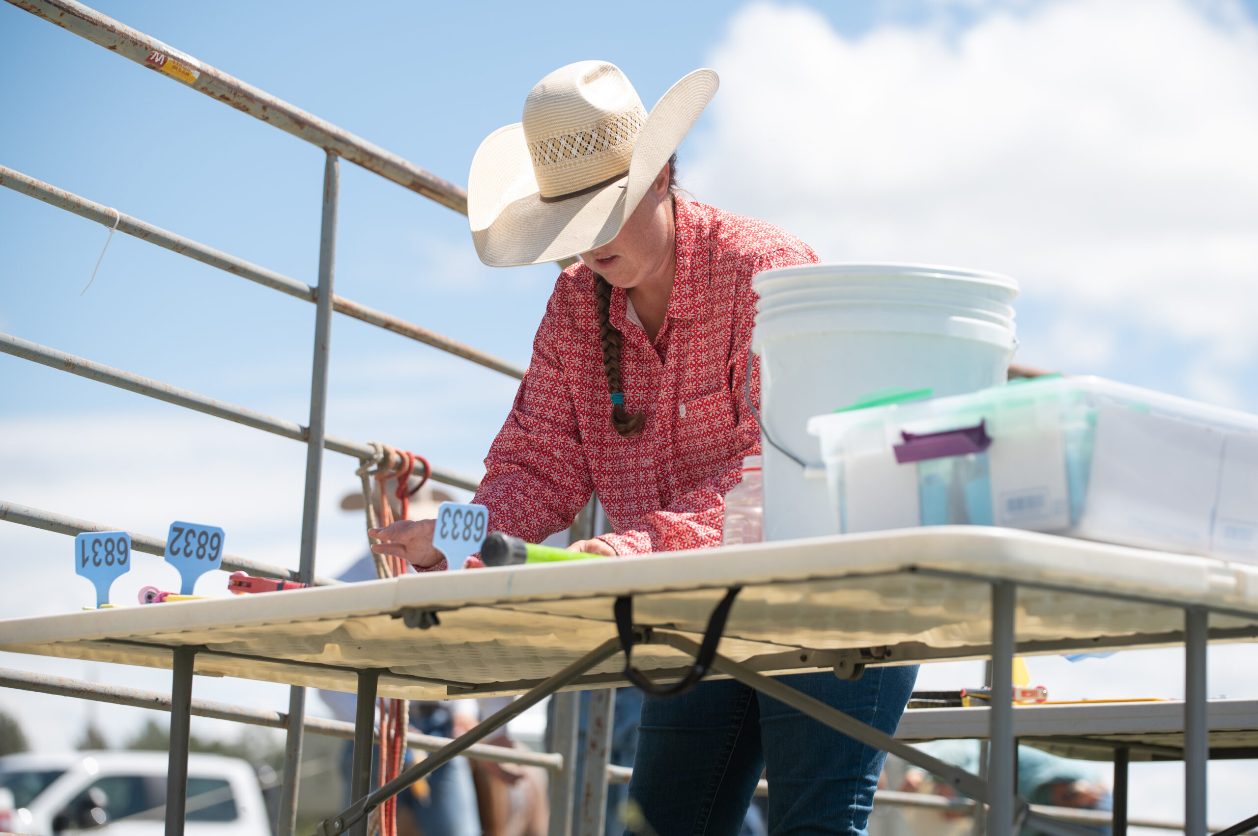 A woman in a cowboy hat providing member services at a table.